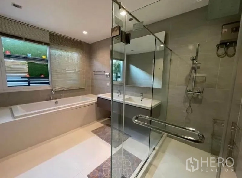 Detached House for rent or sale in Bang Phli, Samut Prakan - Contemporary bathroom with glass-enclosed shower, bathtub and double vanity in neutral tones.