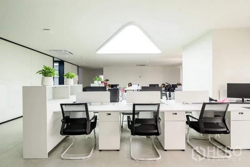 办公空间 出租或出售在Huai Khwang, Bangkok - 白色工位排布于三角形LED天花灯下。