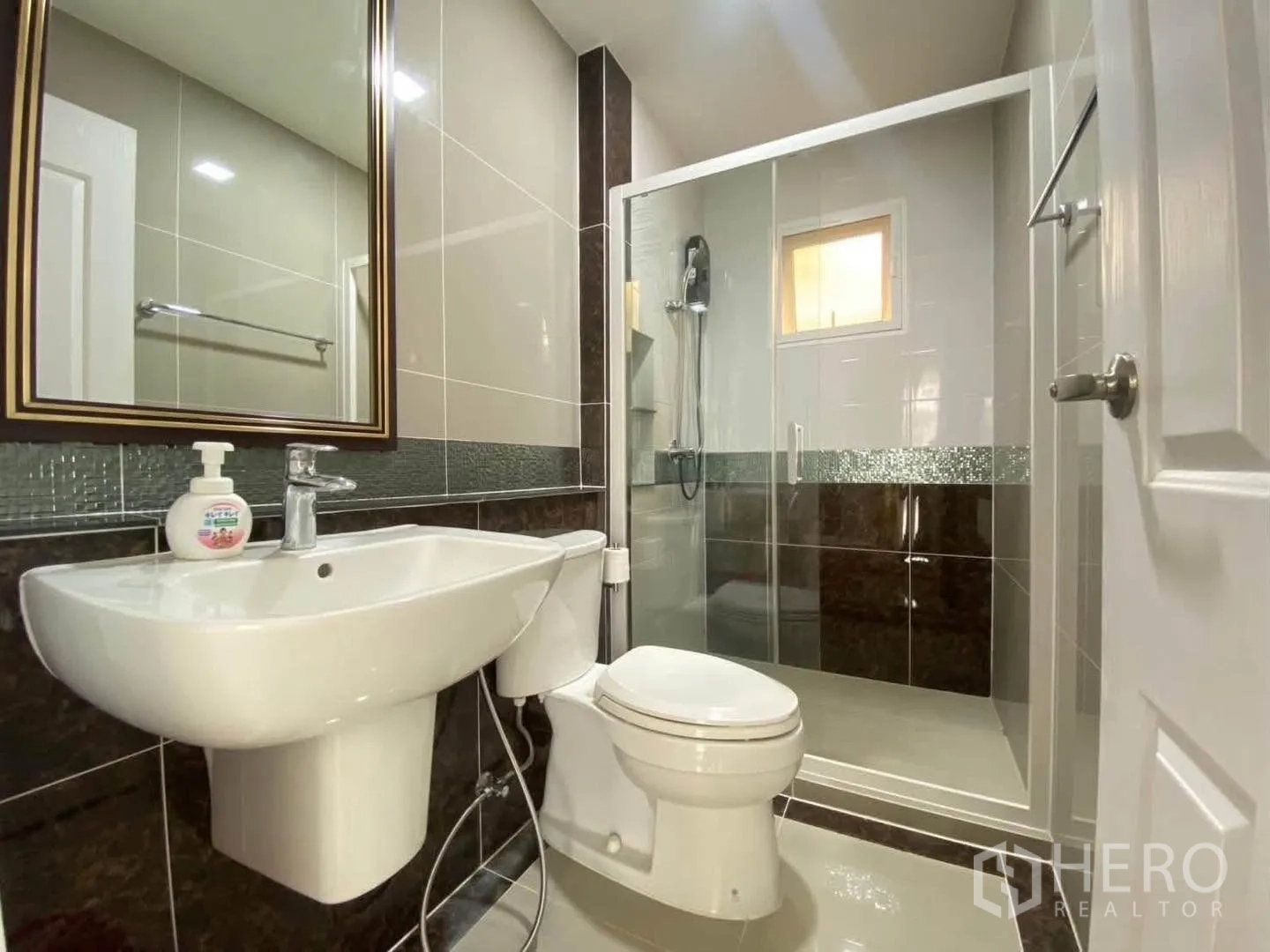 Detached House for rent in Mueang Samut Prakan, Samut Prakan - Bathroom with glass shower enclosure, toilet, and basin.