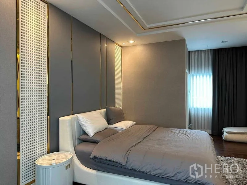 Detached House for sale in Suan Luang, Bangkok - Primary bedroom with upholstered wall panels, recessed lighting and a large bed.