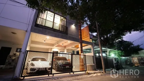ทาวน์เฮาส์ ให้เช่าในKhlong Toei, Bangkok - ด้านหน้าทาวน์เฮ้าส์สมัยใหม่ พร้อมประตูรั้วและที่จอดรถ 2 คันยามค่ำ