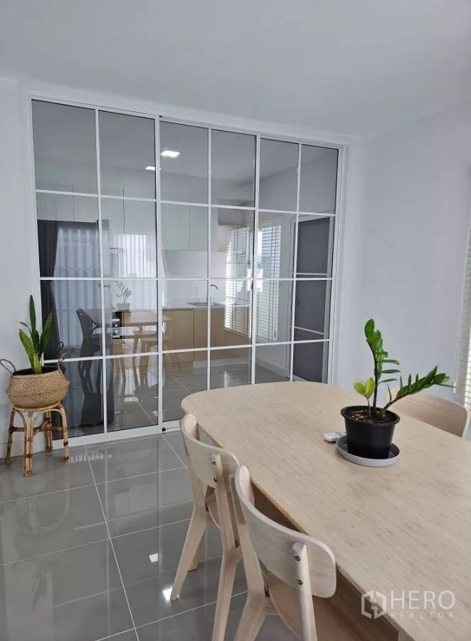 Detached House for rent in Bang Phli, Samut Prakan - Dining space separated by a full-height glass partition facing the enclosed kitchen.