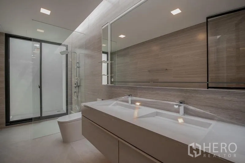 บ้าน ให้เช่า - ห้องน้ำสมัยใหม่ อ่างล้างหน้าคู่ ห้องอาบน้ำกระจก และกระจกบานใหญ่.