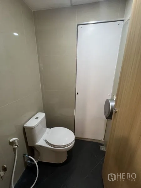 办公空间 出租 - 办公室内独立卫生间，坐便器、喷枪与瓷砖墙面。