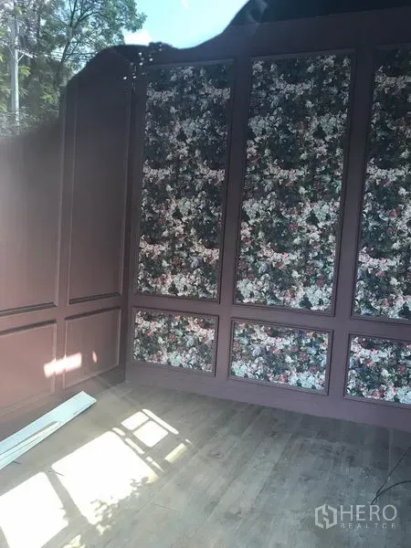 零售空间 出租在Watthana, Bangkok - 小型店铺内景，花卉墙面与木地板，采光良好。