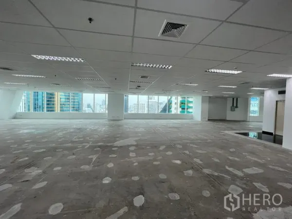 Office Space for rent - Expansive open‑plan office floor with grid ceiling lights, large windows and Bangkok skyline views.