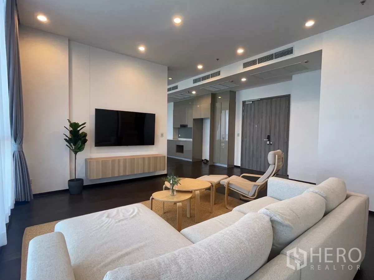 Condominium for rent in Phra Khanong, Bangkok - Open-plan lounge with TV wall, recessed lighting and access to a modern fitted kitchen.