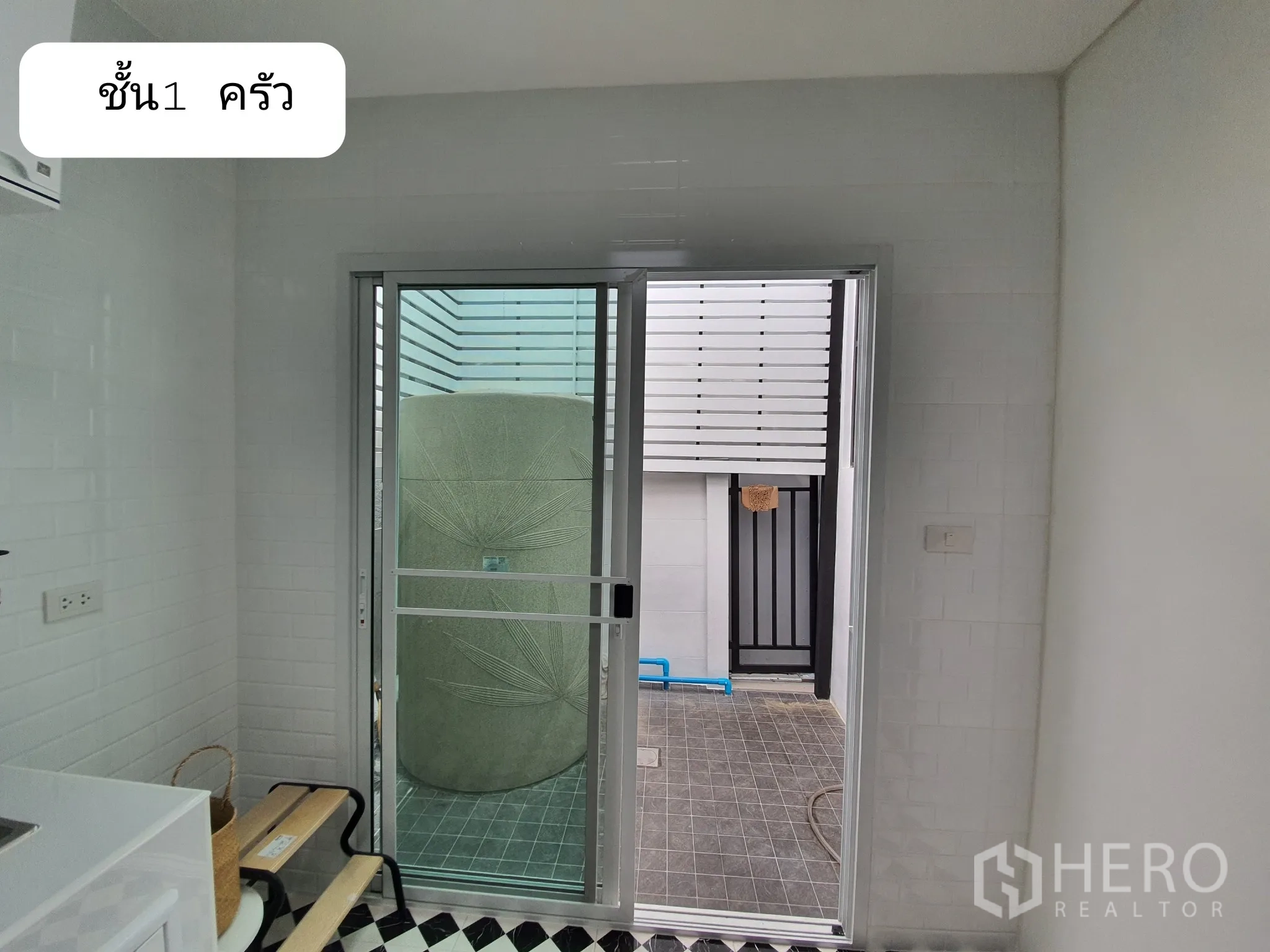 Home Office for rent or sale in Prawet, Bangkok - Ground-floor kitchen sliding door to a small utility yard with outdoor tank.