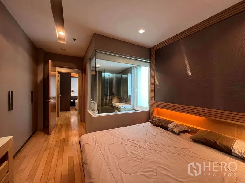 คอนโด ให้เช่าในKhlong Toei, Bangkok - ห้องนอนมาสเตอร์พื้นไม้ พร้อมผนังกระจกกั้นห้องน้ำในตัวและไฟซ่อน