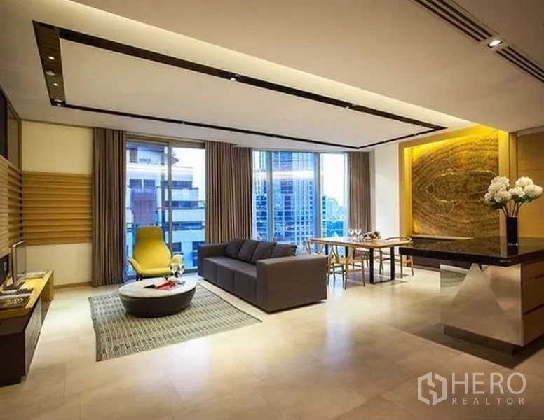 公寓 出租在Bang Rak, Bangkok - 开放式客餐厅，落地窗城市景观与灯光艺术墙。