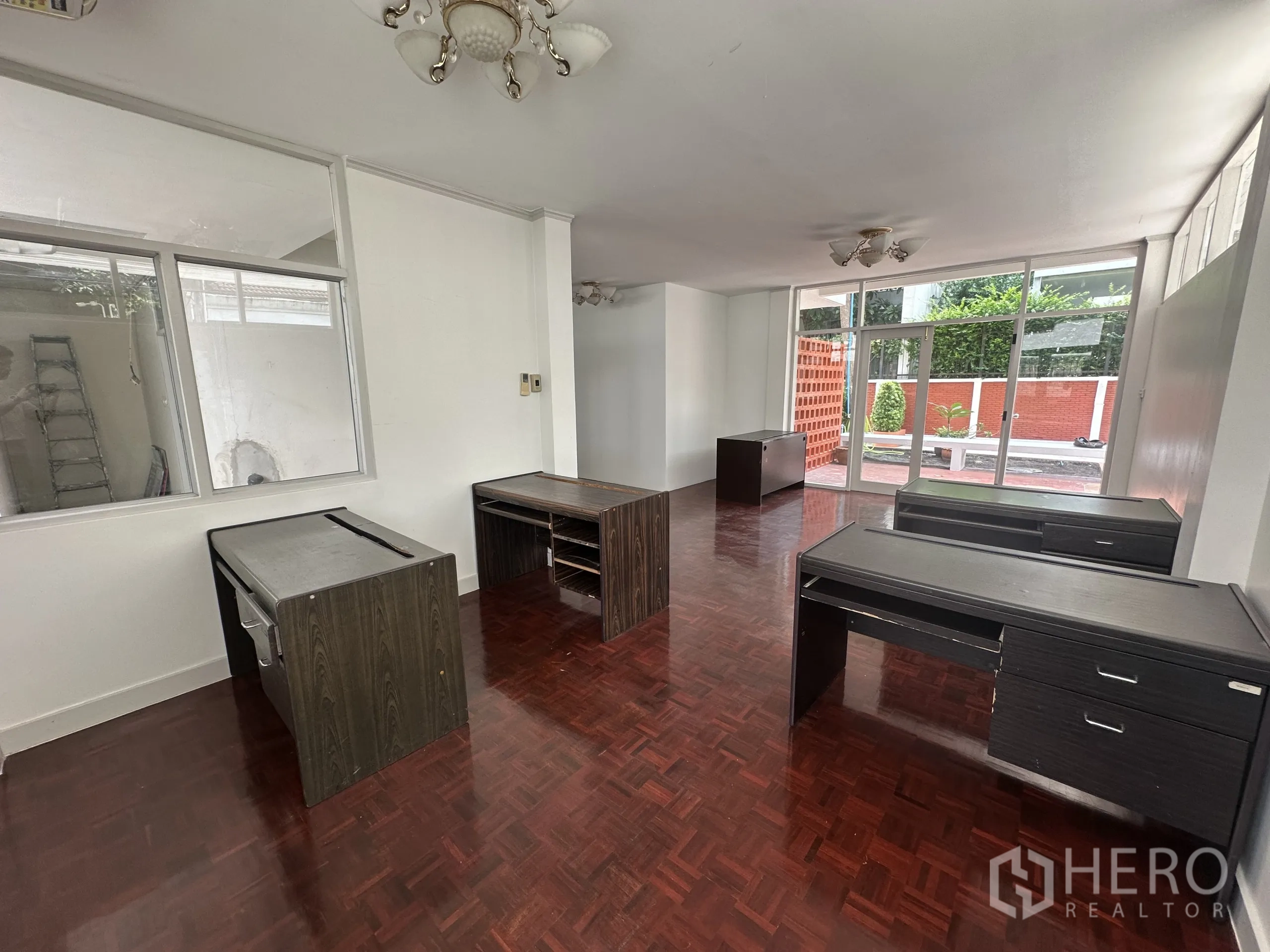 Home Office for rent in Watthana, Bangkok - Reception-style front area with glass frontage, desks and polished wood flooring.