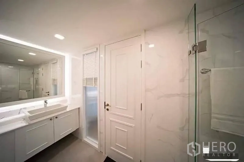 คอนโด ให้เช่าหรือขายในWatthana, Bangkok - ห้องน้ำโมเดิร์น กระจกไฟแบ็คไลต์ โต๊ะเครื่องแป้งสีขาว และตู้ shower กระจก