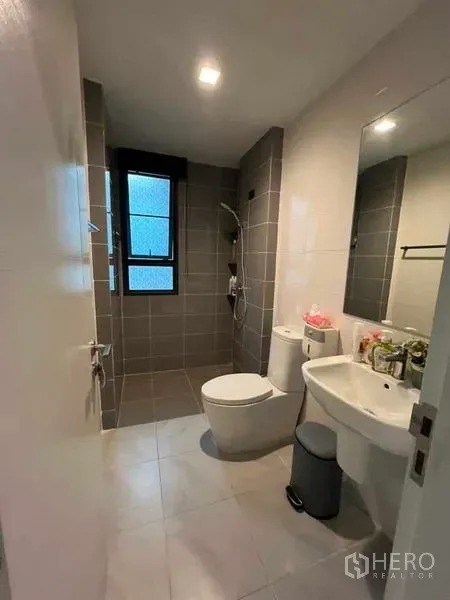 独立式住宅 出售在Khan Na Yao, Bangkok - 灰色瓷砖的浴室，设淋浴区、马桶与带镜子的洗手台。