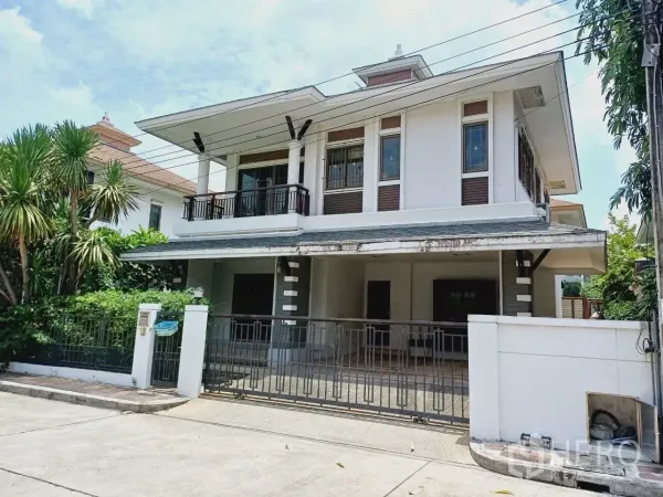 独立式住宅 出租或出售在Mueang Nonthaburi, Nonthaburi - 两层独栋住宅外观，带大门车道与阳台，前院绿化，位于暖武里直辖县。