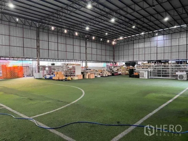 คลังสินค้า ให้เช่าในLat Phrao, Bangkok - ภายในโกดังโครงเหล็กเพดานสูง พื้นหญ้าเทียม ไฟ LED สว่าง พร้อมชั้นวางและกล่องสินค้า