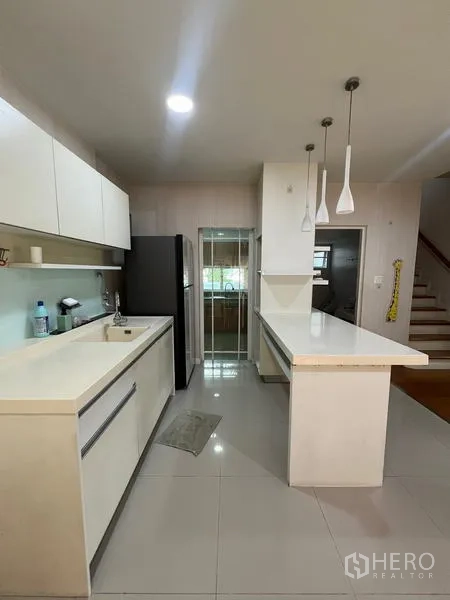 บ้าน ให้เช่าในBang Kapi, Bangkok - ครัวแพนทรีโทนขาว มีไอส์แลนด์ โคมไฟแขวน และตู้เย็นสูง