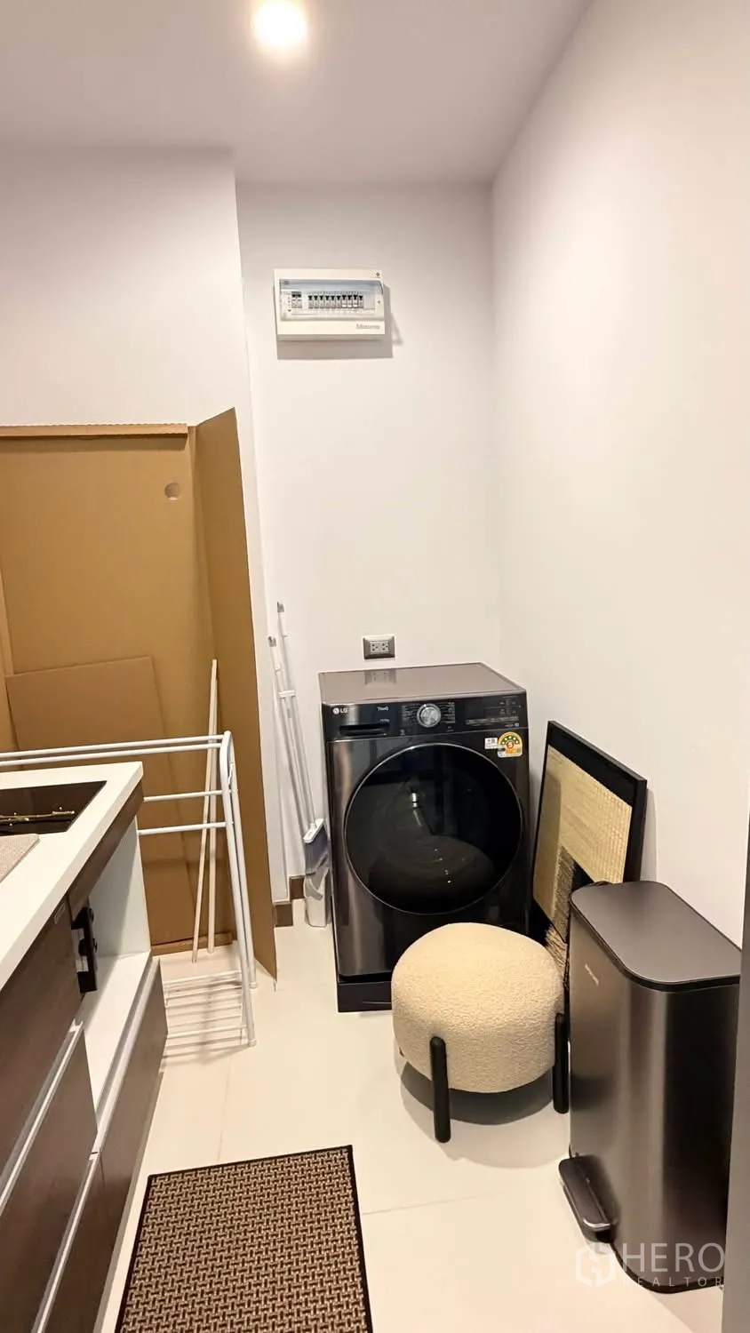 Condominium for rent in Watthana, Bangkok - Laundry nook with a front-load washing machine and storage space.