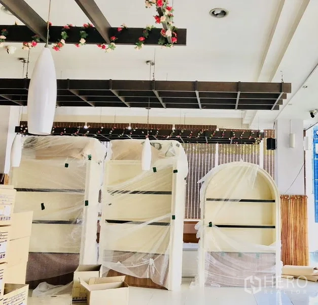 店屋 出租在Lat Phrao, Bangkok - 室内开放式展厅，吊灯与木质格栅天花，包装中的展示柜。
