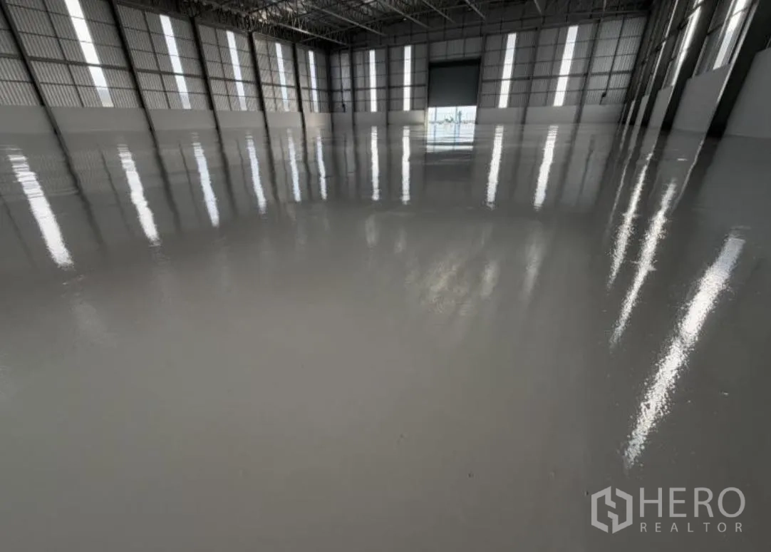 Warehouse for rent in Bang Khun Thian, Bangkok - Interior view with polished floor and roller door at the far end.