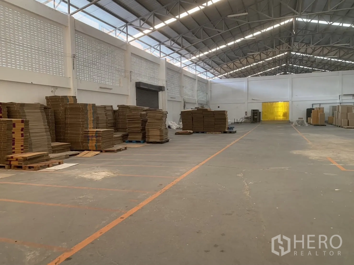โกดัง for rent in Bang Phli, Samut Prakan - พื้นโกดังกว้างเห็นประตูม้วน ผนังบล็อกช่องลม และพาเลทสินค้า