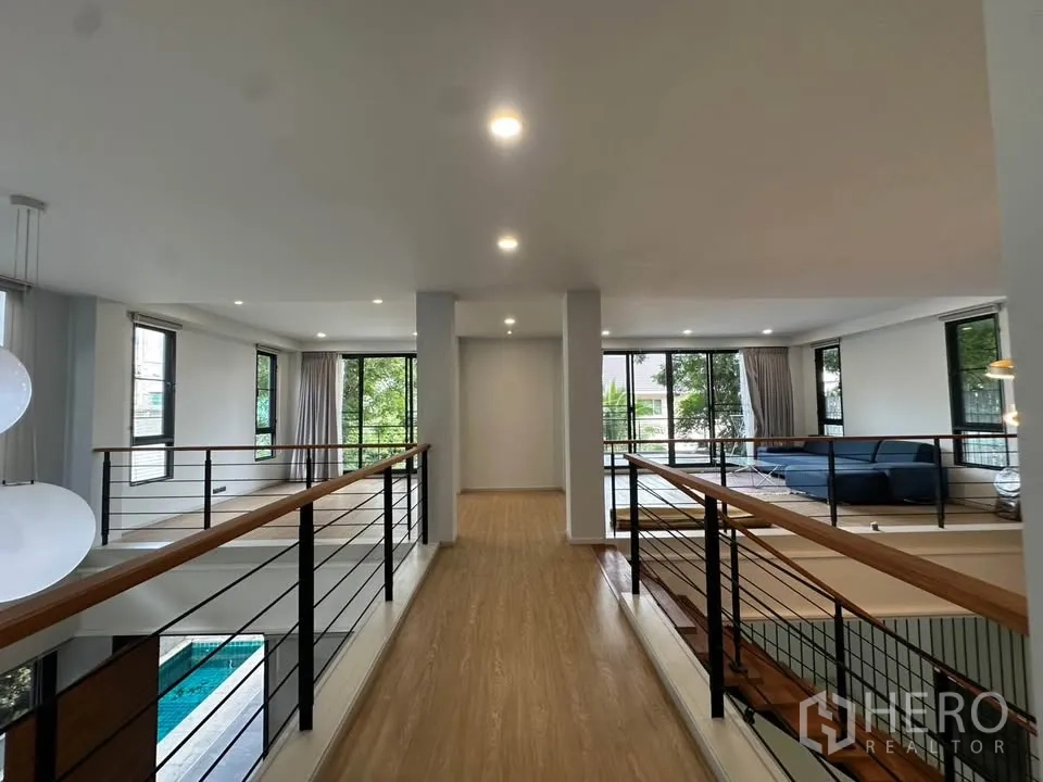 Detached House for sale in Watthana, Bangkok - Long upstairs hallway with railings and windows on both sides.