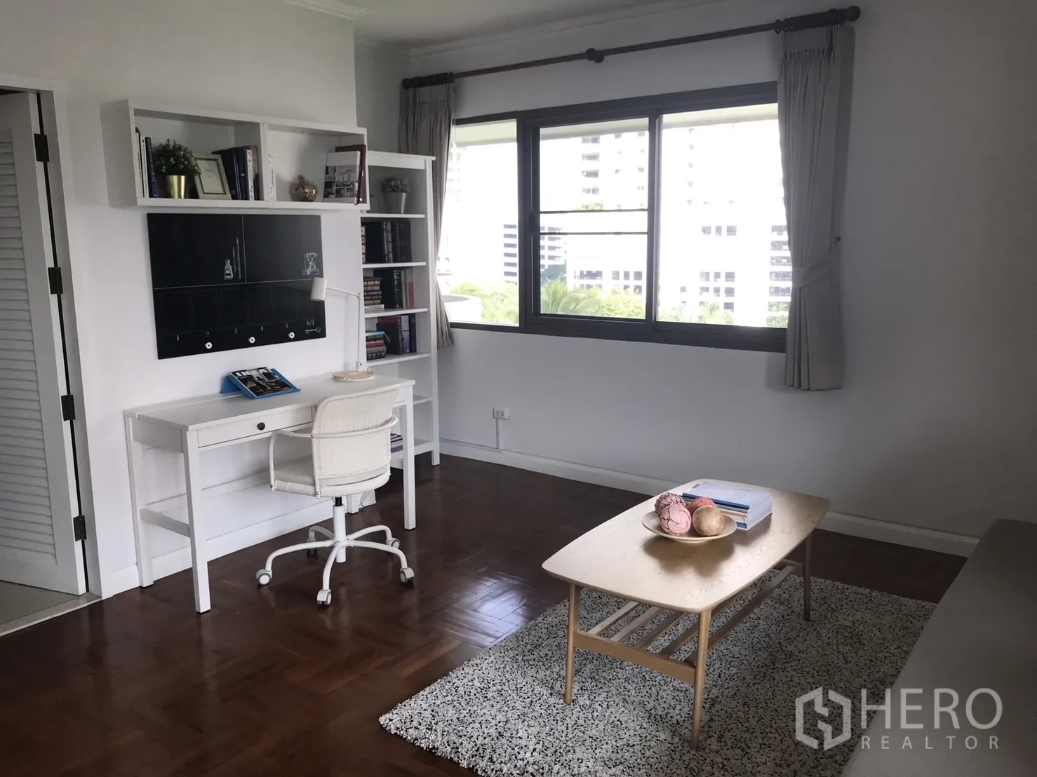 คอนโด ให้เช่าในBangkok - ห้องทำงานหรือห้องนอนพร้อมโต๊ะสีขาว ชั้นหนังสือ และหน้าต่างบานใหญ่