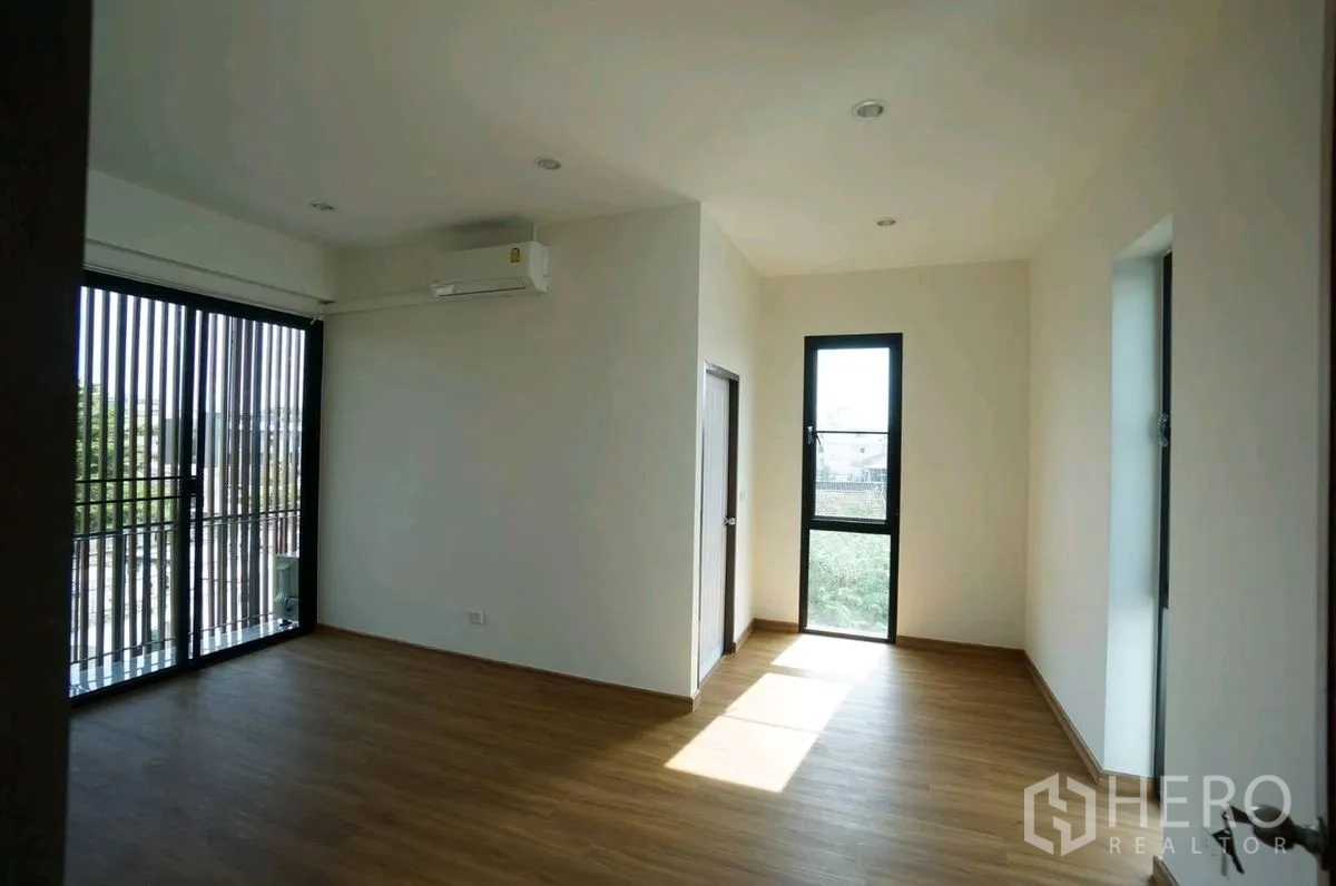家庭办公室 for rent in Chatuchak, Bangkok - 转角房间铺木地板，带阳台玻璃门与高窗。