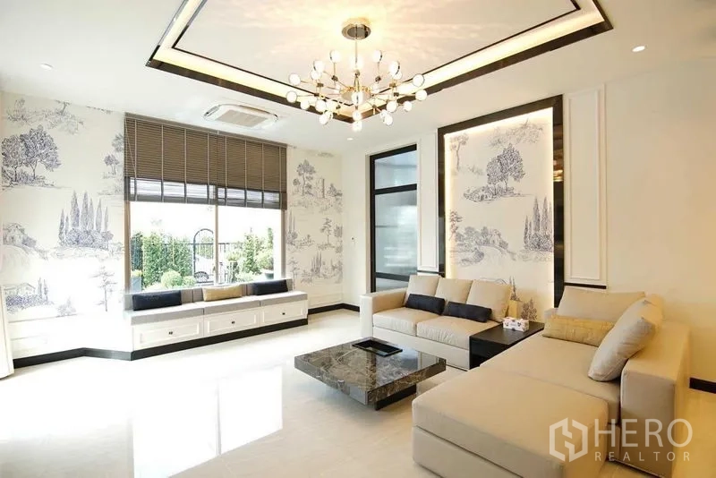 บ้าน ขายในLat Krabang, Bangkok - ห้องนั่งเล่นสว่าง โคมระย้าและวอลล์เปเปอร์ลายทิวทัศน์