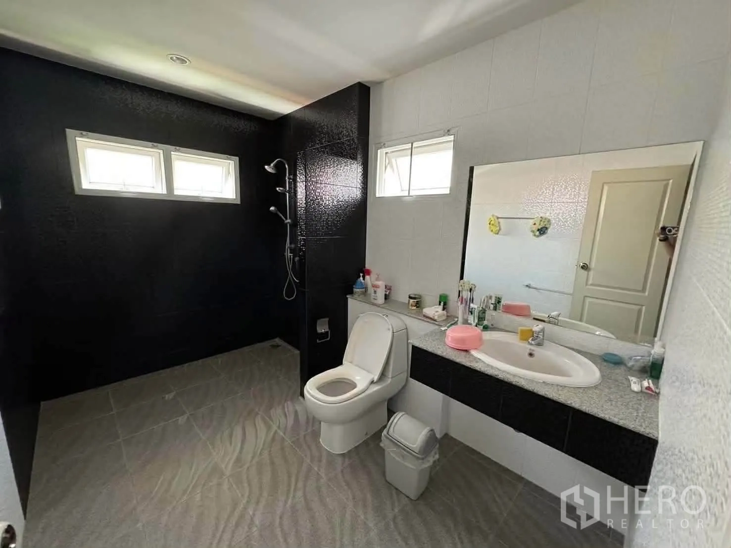 Detached House for rent in Watthana, Bangkok - Another angle of the large bathroom showing toilet, wide mirror, and shower with small windows.