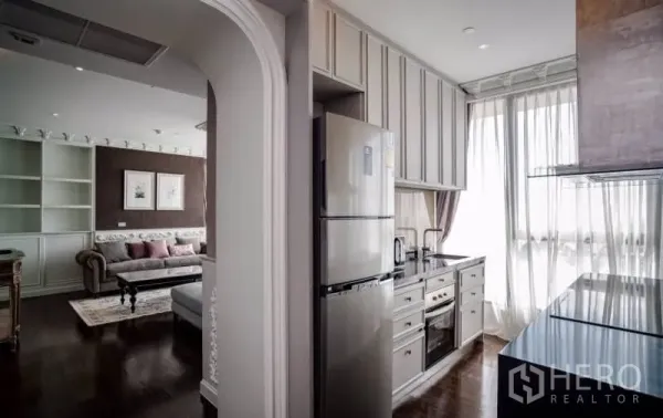 Condominium for rent or sale in Khlong Toei, Bangkok - Compact separate kitchen with full-height cabinets, built-in oven and large windows beside the living area.