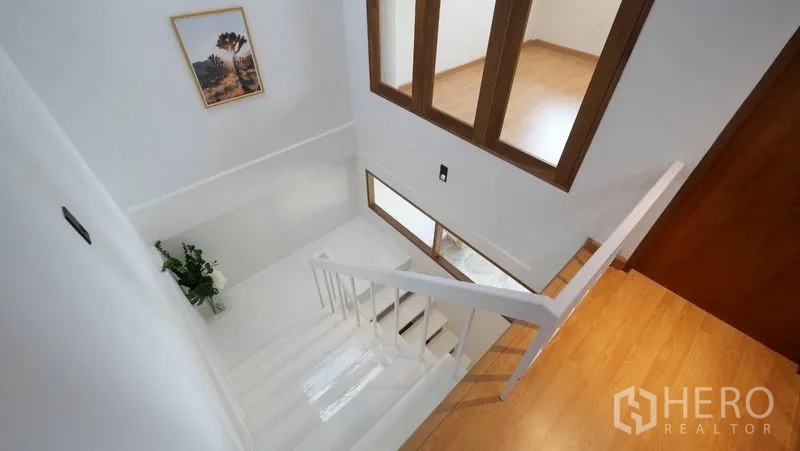 ทาวน์เฮาส์ ให้เช่าในKhlong Toei, Bangkok - โถงบันไดสีขาว ราวจับเรียบ กับหน้าต่างกรอบไม้รับแสงธรรมชาติ