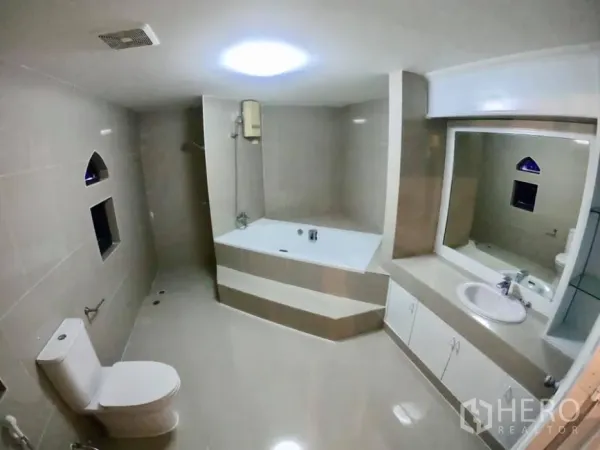 Townhouse for rent in Watthana, Bangkok - Spacious tiled bathroom featuring a soaking bathtub, separate shower, large mirror and toilet.