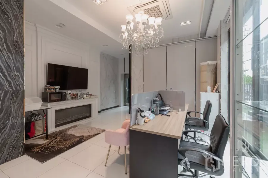 Home Office for sale in Don Mueang, Bangkok - Ground-floor reception workspace with desk, TV, chandelier lighting and glass frontage.
