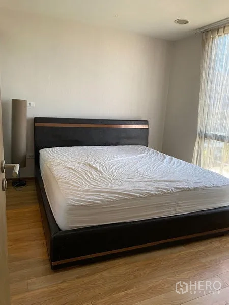 คอนโด ให้เช่าหรือขายในPhaya Thai, Bangkok - ห้องนอนหลักสว่าง เตียงขนาดใหญ่ พื้นไม้ พร้อมหน้าต่างบานใหญ่และผ้าม่านโปร่ง