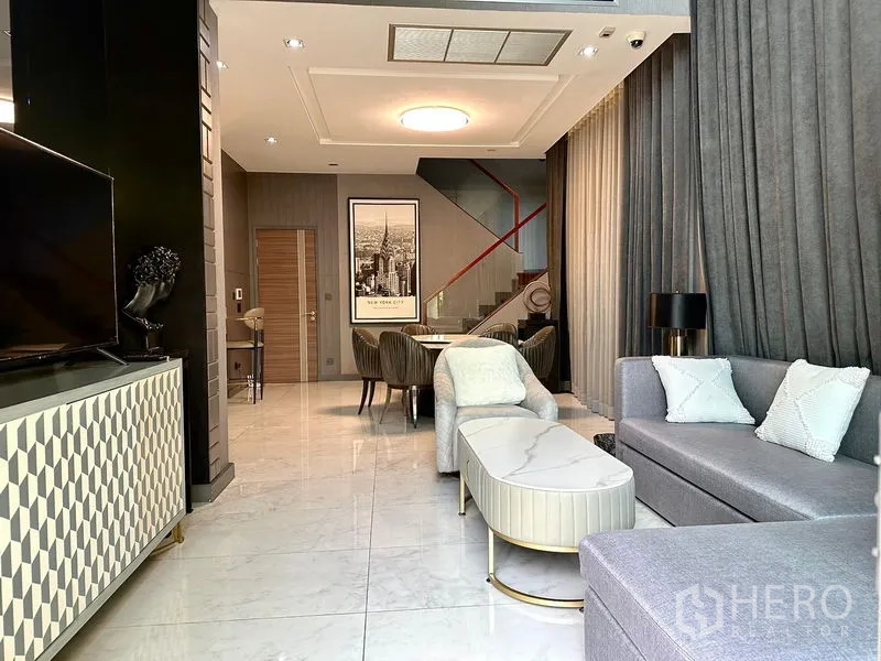 บ้าน ให้เช่าในPhra Khanong, Bangkok - โถงรับแขกและกินข้าวเพดานสูง พร้อมโซฟาตัวแอลสีเทา