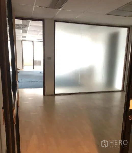 办公空间 出租在Watthana, Bangkok - 入口走道与木地板，磨砂玻璃隔断通向开放式办公区