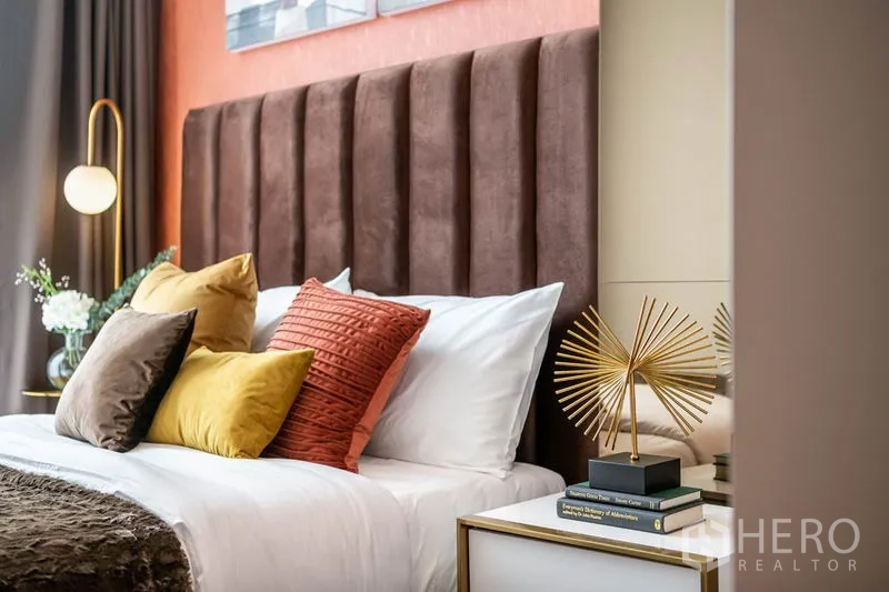 公寓 出租或出售在Watthana, Bangkok - 床侧视角，黄铜吊灯与质感特色墙面。