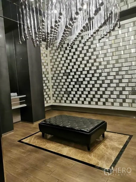 公寓 出租在Watthana, Bangkok - 时尚会客区，艺术吊灯、皮质长凳与镜面特色墙。