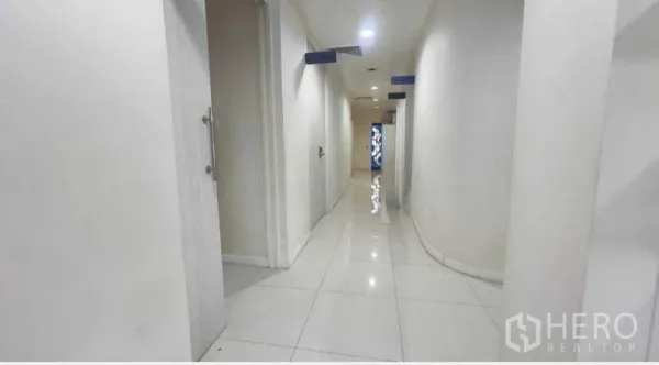 独立商业地产 出租在Khlong Toei, Bangkok - 明亮的白色瓷砖走廊，多扇房门通往各功能房。