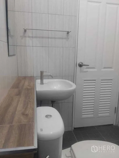 บ้าน ขายในPhra Khanong, Bangkok - ห้องน้ำกะทัดรัด ผนังปูกระเบื้อง อ่างล้างหน้า โถสุขภัณฑ์ และเคาน์เตอร์ไม้