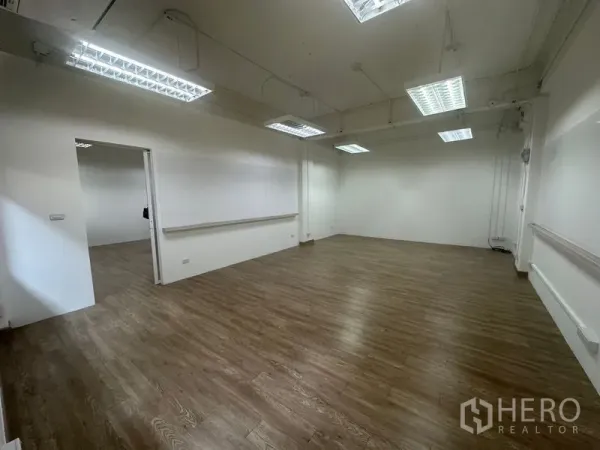 สำนักงาน ให้เช่าในChatuchak, Bangkok - พื้นที่สำนักงานกว้าง มุมห้อง เพดานแขวนไฟฟลูออเรสเซนต์ รางเก็บสาย และประตูบานเลื่อนไปยังห้องข้างเคียง