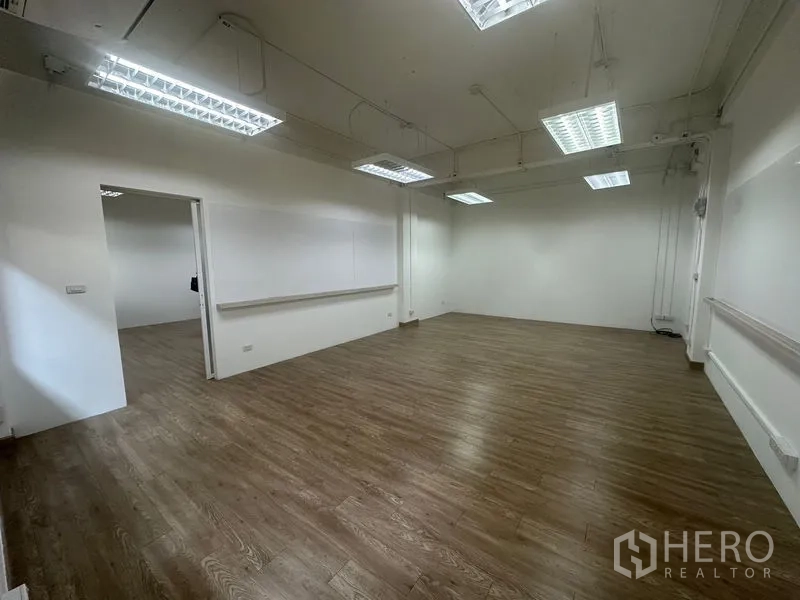 สำนักงาน ให้เช่าในChatuchak, Bangkok - พื้นที่สำนักงานกว้าง มุมห้อง เพดานแขวนไฟฟลูออเรสเซนต์ รางเก็บสาย และประตูบานเลื่อนไปยังห้องข้างเคียง