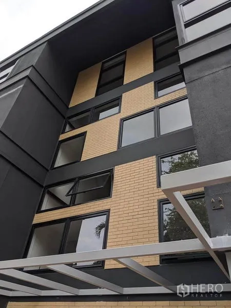 带办公室的家 出租或出售在Phaya Thai, Bangkok - 建筑外立面特写，米色砖饰面与深色外墙。