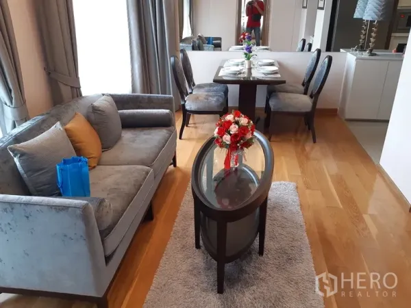 คอนโด ให้เช่าในWatthana, Bangkok - พื้นที่นั่งเล่นและทานอาหารแบบโอเพ่น มีโซฟา โต๊ะกลางกระจก และโต๊ะอาหาร 4 ที่นั่งบนพื้นไม้