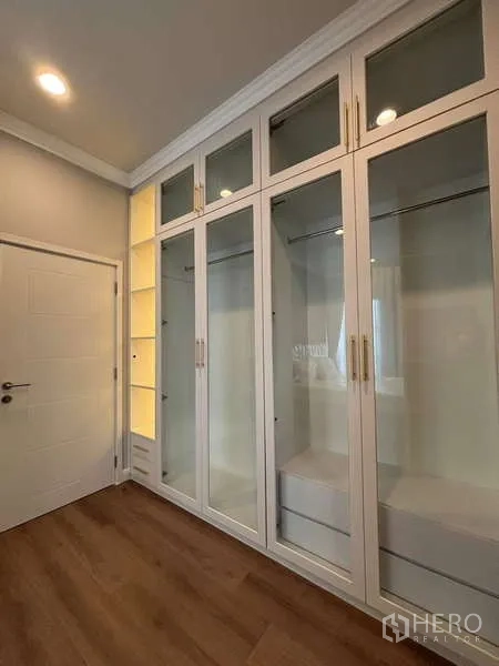 Detached House for rent in Bang Phli, Samut Prakan - Built-in wardrobe with glass doors and open illuminated shelving.