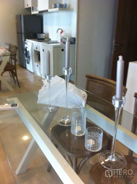 คอนโด ให้เช่าในBangkok - โต๊ะทานอาหารกระจกจัดโต๊ะ ข้างครัวขนาดกะทัดรัดและตู้เย็น