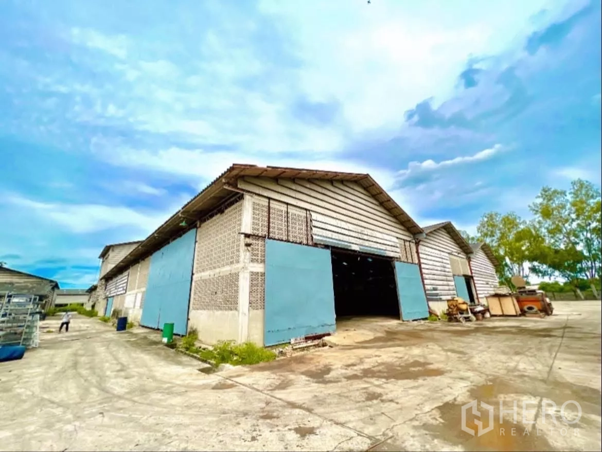 工厂 出租在Sai Noi, Nonthaburi - 山墙式仓库区，蓝色推拉大门，卡车通道便捷。