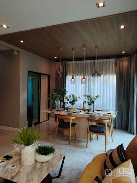 Detached House for rent in Bang Phli, Samut Prakan - Dining room with wooden table and pendant lights beside sliding glass doors.