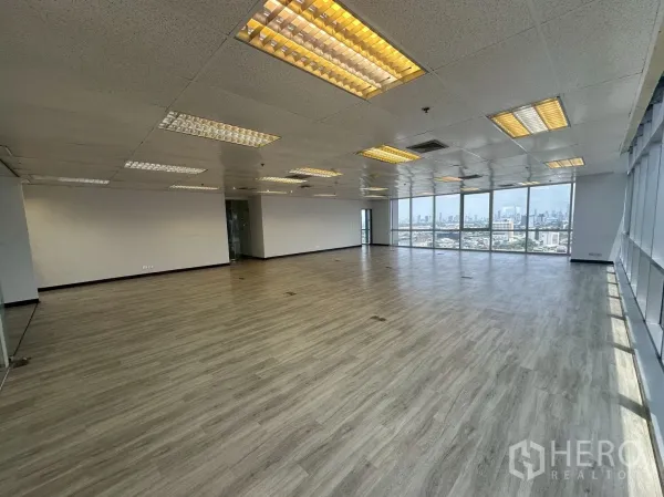 Office Space for rent - Modern office zone with wide windows on two sides and vinyl plank flooring.