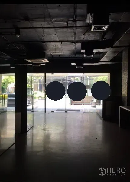 办公空间 出租在Pathum Wan, Bangkok - 面向落地玻璃临街面的开放式空间，黑色外露天花与风管空调。